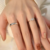 Close-up view of diamond bridal set on hand, sparkling center stone engagement ring and classic men’s wedding band in white gold.